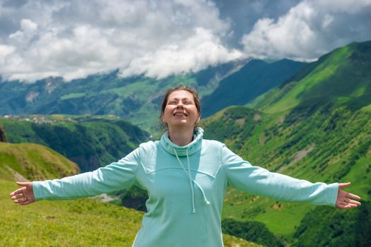 Happy woman enjoys the freedom to travel in the mountains