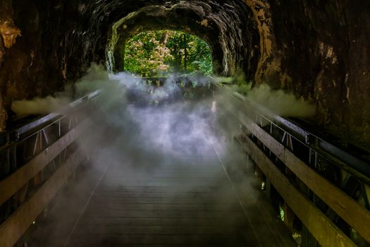 creepy looking halloween cave with lots of smoke, misty cavern walking path, horror scenery