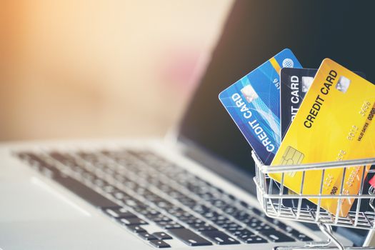 Shopping cart and credit card with laptop on the desk