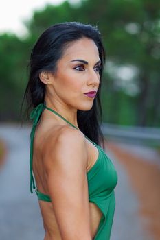 Fitness girl posing with a beautiful green 
swimsuit