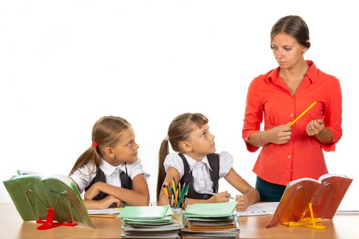 Children at their desks look at the angry teacher with fear
