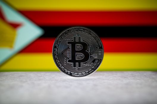 Physical silver version of Bitcoin (BTC) and Zimbabwe Flag on th