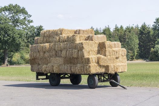 Plain old farm wagon with straw bales stacked
