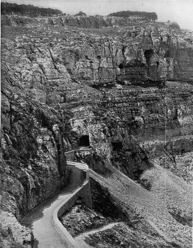 Mountain road with hollow tunnels in stratified rocks near Const