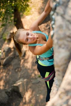 Portrait of a Beautiful Woman Climbing on the High Rock in the Mountains. Adventure and Extreme Sport Concept