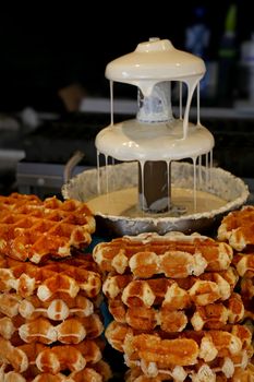 Close up Belgian wafers and white chocolate fountain