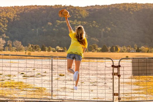 Aussie woman standing on a rural farm gate