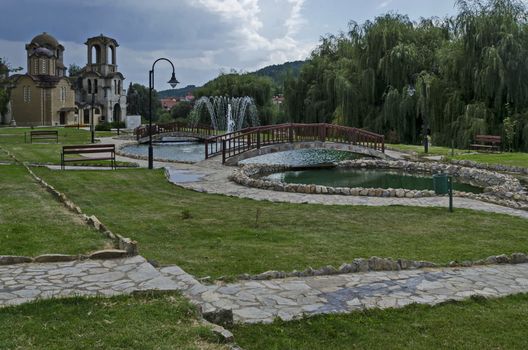 General view of public garden  in  residential district with new orthodox church, two artificial ponds, fountain and two bridges, town Delchevo