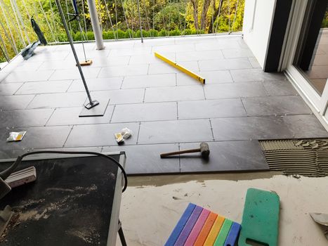 Balcony floor tiles installation. Laying tiles from porcelain. Interior remodeling theme.