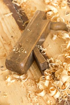 Discarded old wooden hand plane for woodworking with wood shavings.