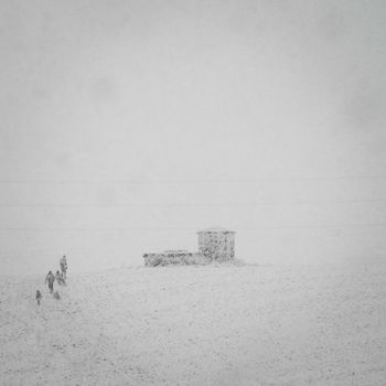 4 people climbing the hill under heavy snow