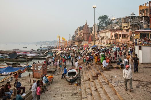 People wash and bath in Ganges river at one of the many ghats of