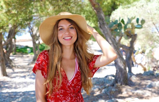 Portrait of a beautiful smiling girl wearing hat and red dress l