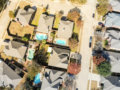 Aerial view a rich subdivision neighborhood with swimming pool and bright autumn leaves