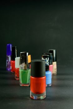 Coloured nail polish bottles on dark background