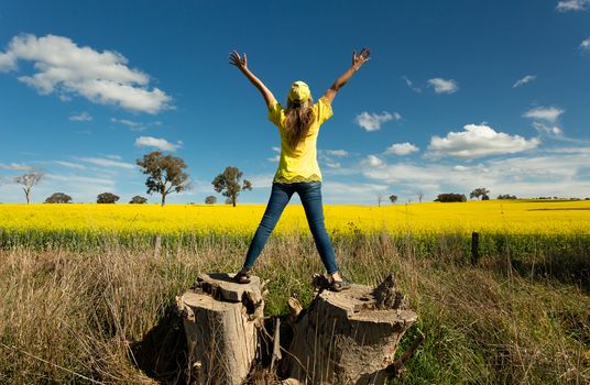 Woman enjoys the countryside views fields of golden canola