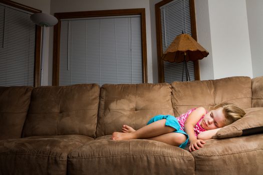 Child on couch curled up into a little ball. lighting focus on child falling off as it moves away