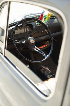 Steering wheel on vintage car. Opened window on old vintage car.