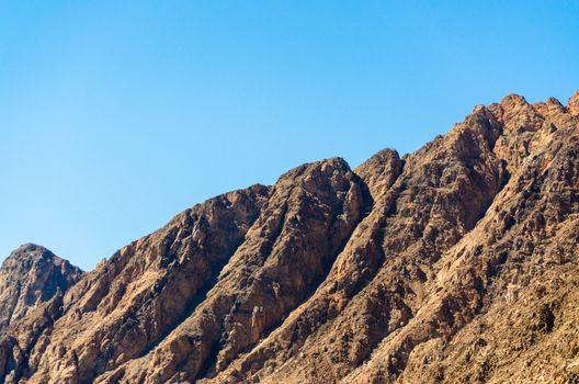 peaks of high rocky mountains against a blue sky in Egypt