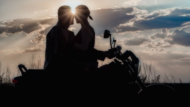 romantic silhouette couple man and woman on a motorcycle on the 