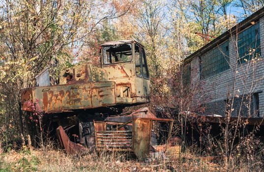 abandoned broken equipment car among trees in Chernobyl Ukraine in autumn