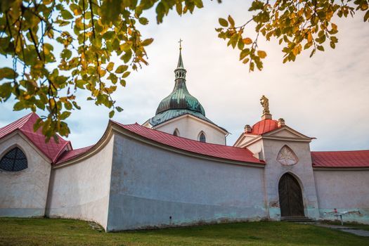 Pilgrimage Church of St John of Nepomuk at Zelena hora in Zdar nad Sazavou, national cultural heritage and the UNESCO World heritage monument - close up shot with autumn leaves in the foreground.