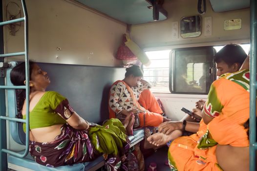 Patna India May 2019 - Tired exhausted woman Passengers falling asleep in a long ride, sitting in their seat and taking a nap inside a train compartment while traveling in public rail transportation