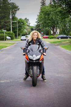 Young woman, on her sport motocycle, ready to ride