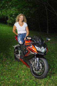 sexy blond woman sitting on top of a sport motocycle