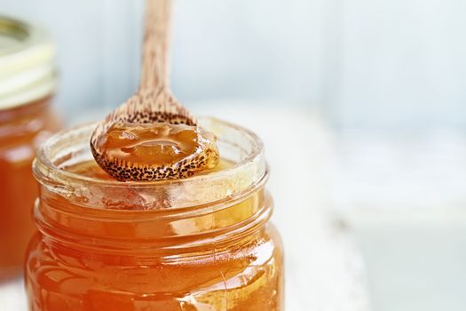 Wood Spoon of Cantaloupe Jam Resting on Jar