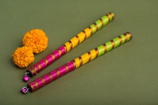 Indian Festival Dussehra and Navratri, showing golden leaf (Bauhinia racemosa) and marigold flowers with Dandiya sticks.