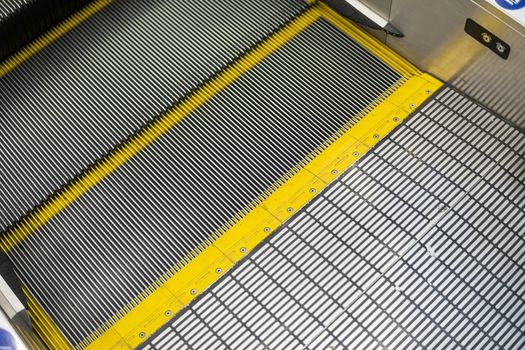 Ditry stairs on Escalator with yellow strips.