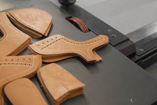 Different forms of leather pieces which will be use for making a shoes on a shoes factory. Prepared, bundled leather parts, used in the production of shoes.