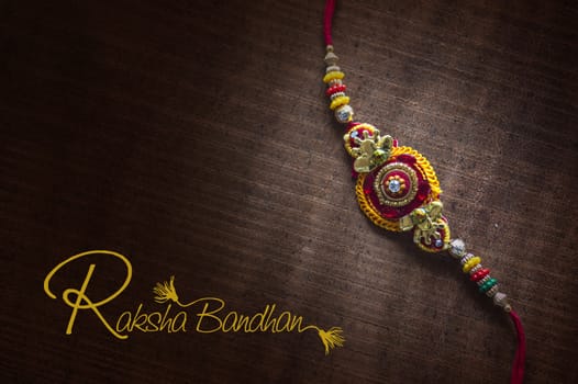 Raksha Bandhan background with an elegant Rakhi. A traditional Indian wrist band.