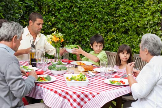 Happy family eating in the garden