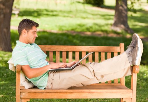 Young man with his laptop in a park