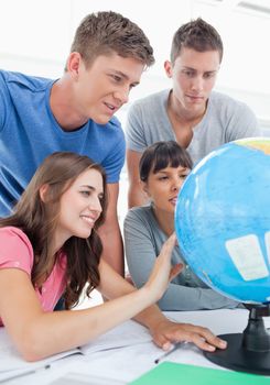 Close up of four people looking at the globe of the world 