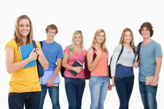 A group of college students standing as one girl stands in front of them