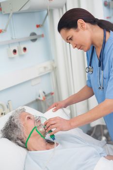 Nurse putting oxygen mask on a patient