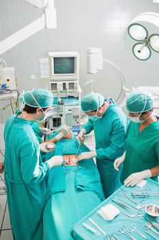 Group of surgeon operating an unconscious patient in an operating theater