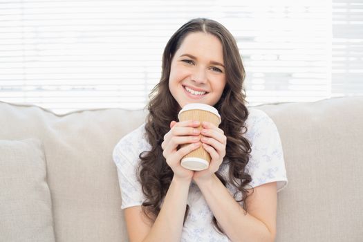 Cheerful pretty woman in pyjamas having coffee