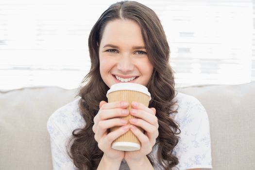 Smiling pretty woman in pyjamas having coffee