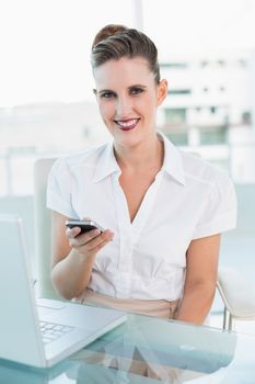 Cheerful attractive businesswoman using phone
