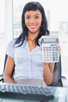 Delighted businesswoman holding a calculator