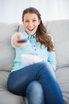 Smiling woman changing tv channel