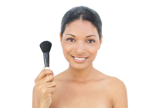 Pretty black haired model holding blusher brush