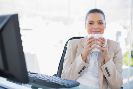 Relaxed sophisticated businesswoman smelling coffee