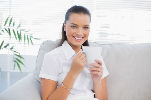 Smiling gorgeous woman holding hot coffee