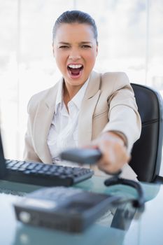 Furious businesswoman screaming while hanging up the phone