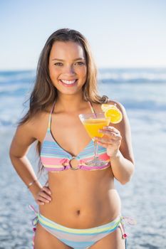 Happy gorgeous woman in bikini holding cocktail